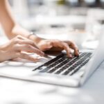 Une femme tapant sur un clavier d'ordinateur