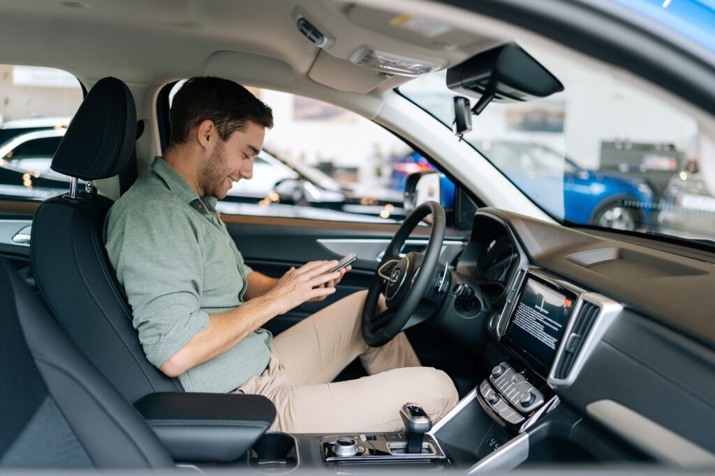 jeune homme avec téléphone portable au volant de sa voiture