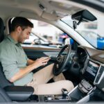 jeune homme avec téléphone portable au volant de sa voiture